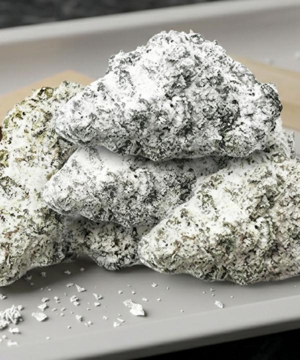 Frosty Gelato Snowcaps cannabis buds with heavy white trichome dusting on a rolling tray.